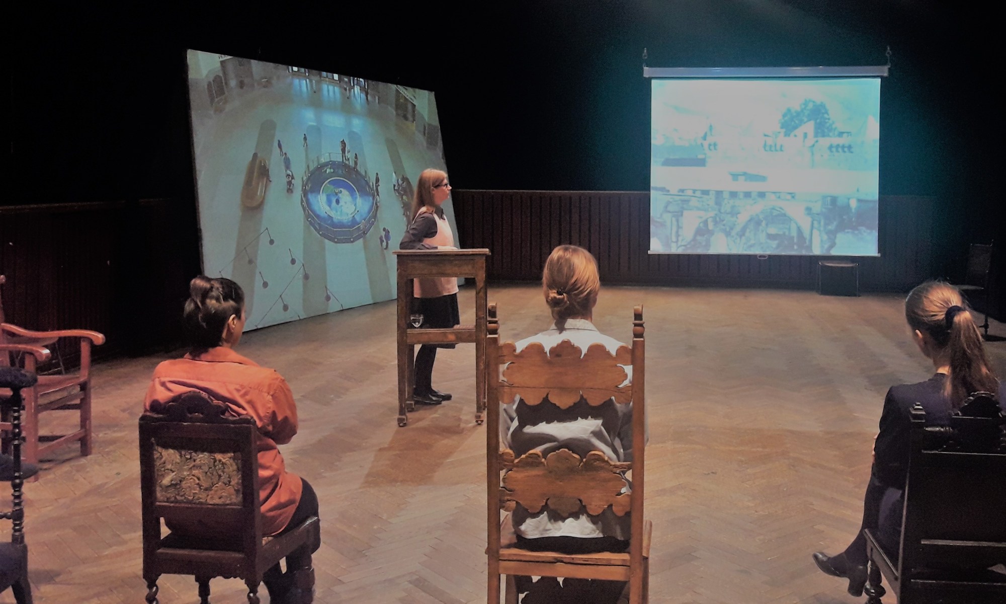 Personen auf Bühne mit Videoprojektionen