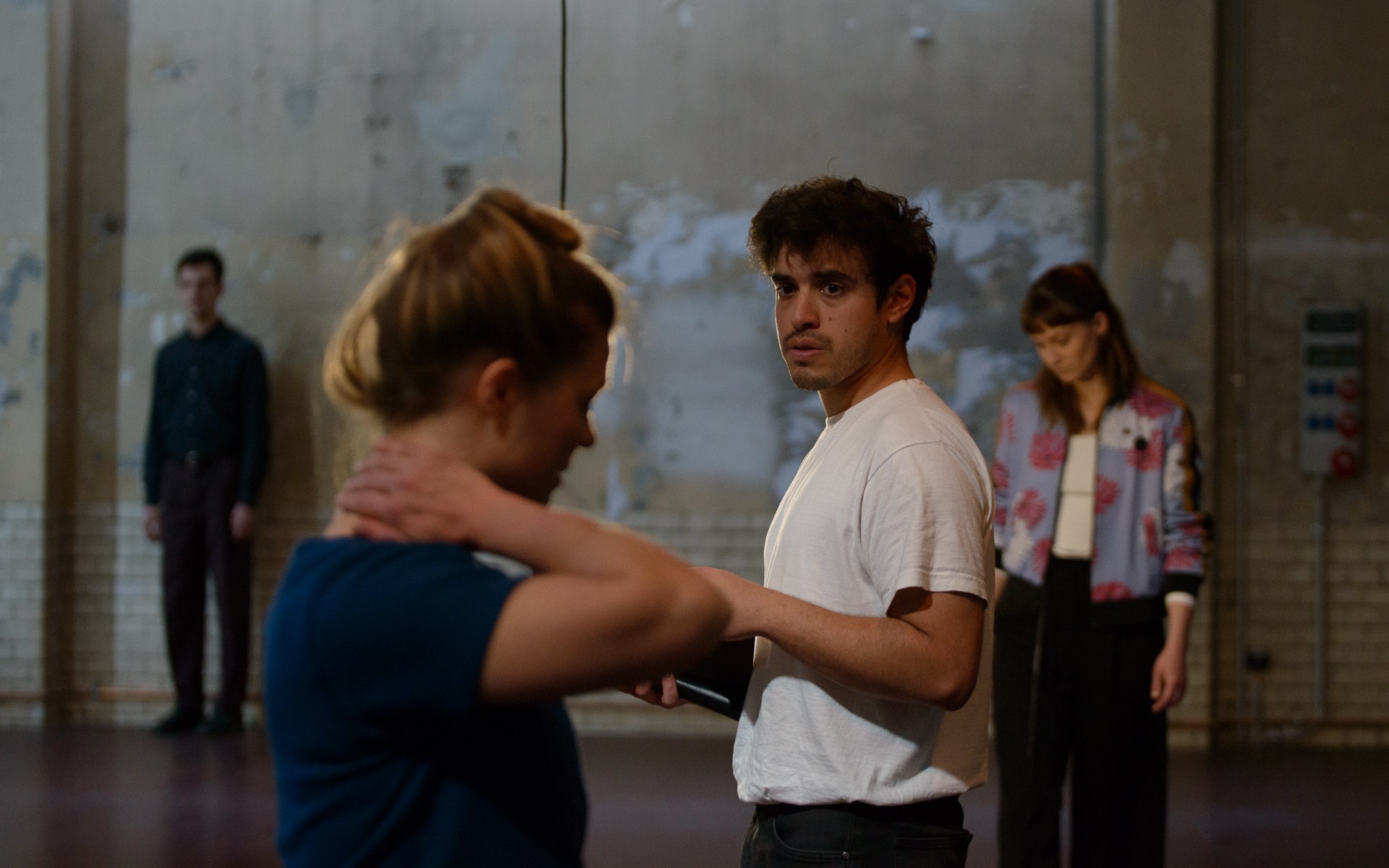 Zwei Personen vorn, zwei hinten vor grauer Wand