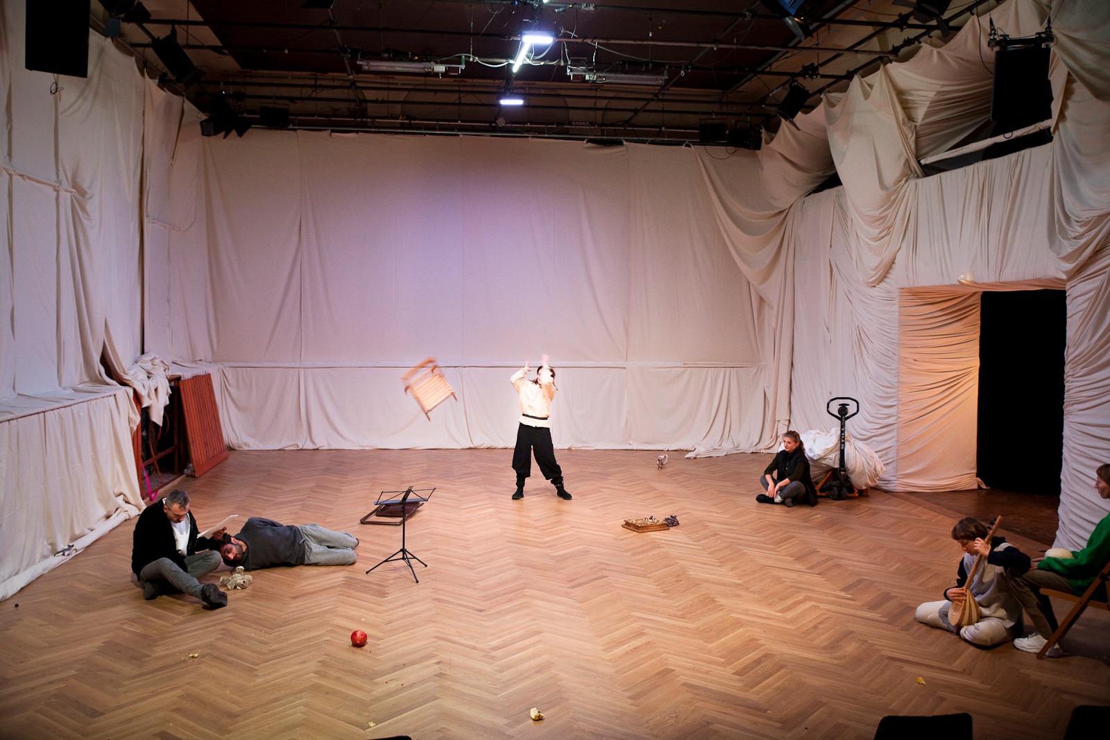 Darsteller auf Bühne mit hellen Stoffwänden